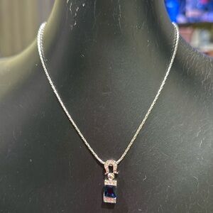 Silver chain, with blue and silver charm.